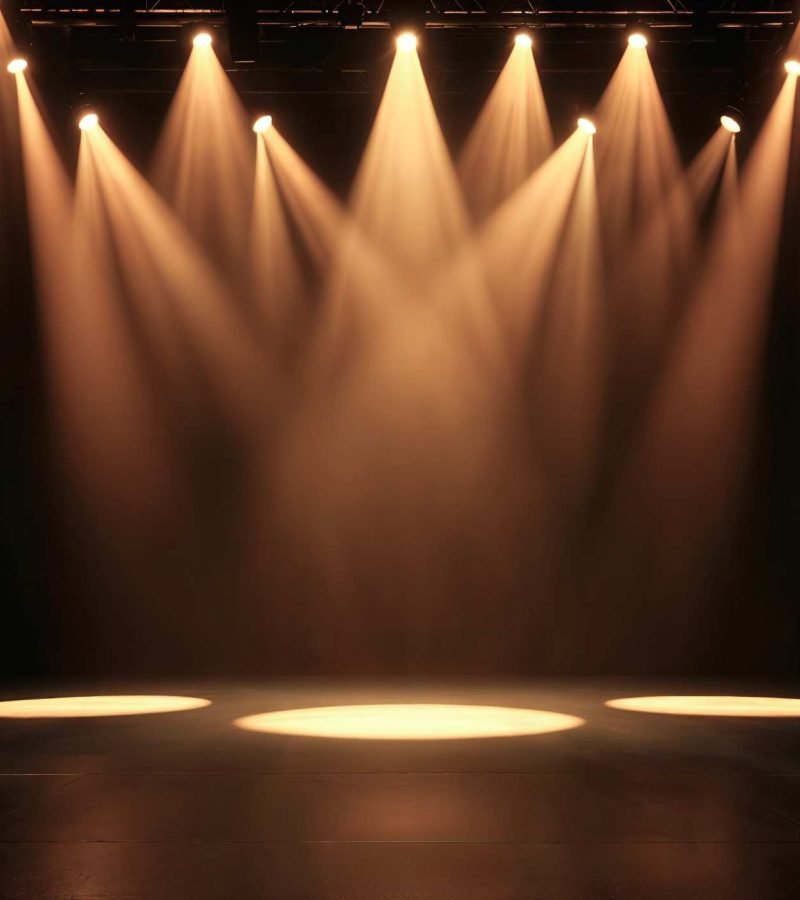 Técnico instalando sistema de iluminación teatral profesional en un escenario de Madrid con ópticas ajustadas a la obra escénica.